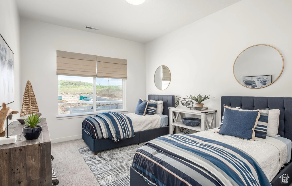 Carpeted bedroom featuring baseboards and visible vents