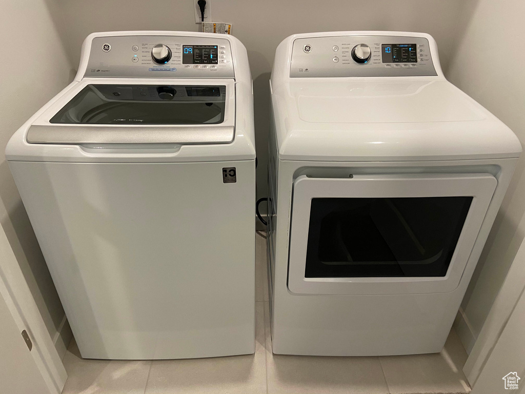 Washroom featuring laundry area, tile patterned flooring, and washing machine and dryer