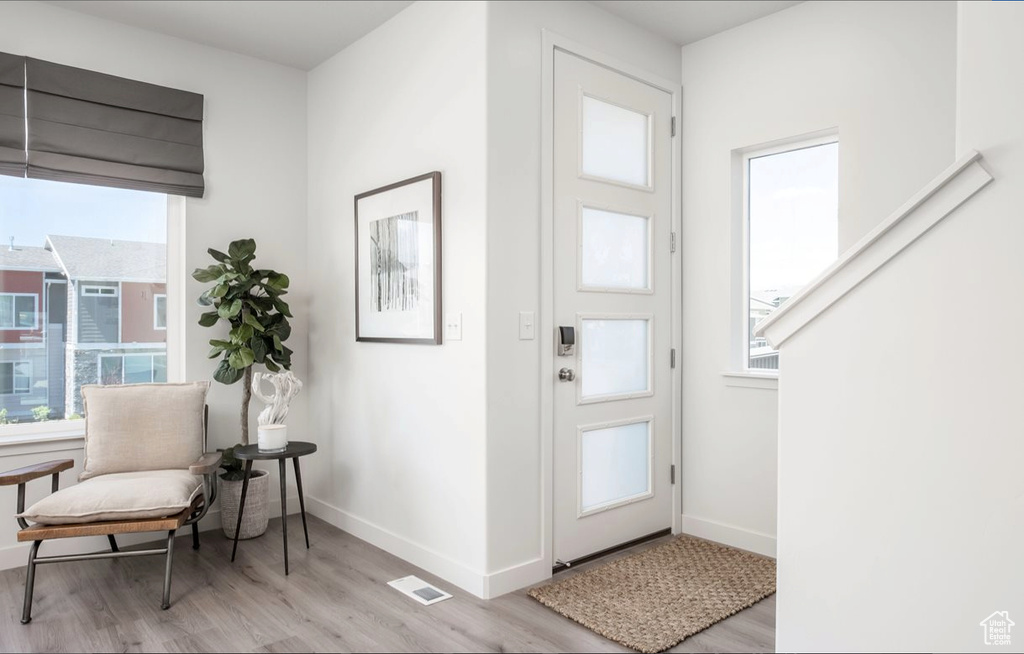 Foyer with baseboards, visible vents, and light wood-style floors
