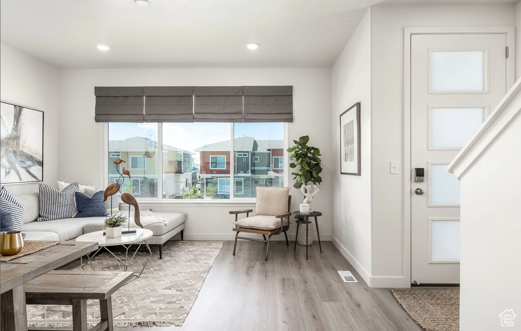 Living room featuring recessed lighting, baseboards, visible vents, and light wood-style floors