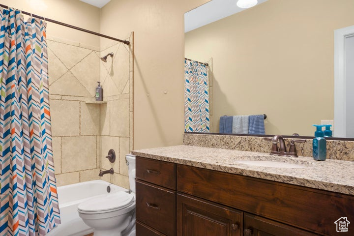 Bathroom with vanity, toilet, and shower / tub combo