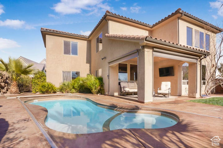 Back of house with a patio, an outdoor pool, stucco siding, and a tile roof