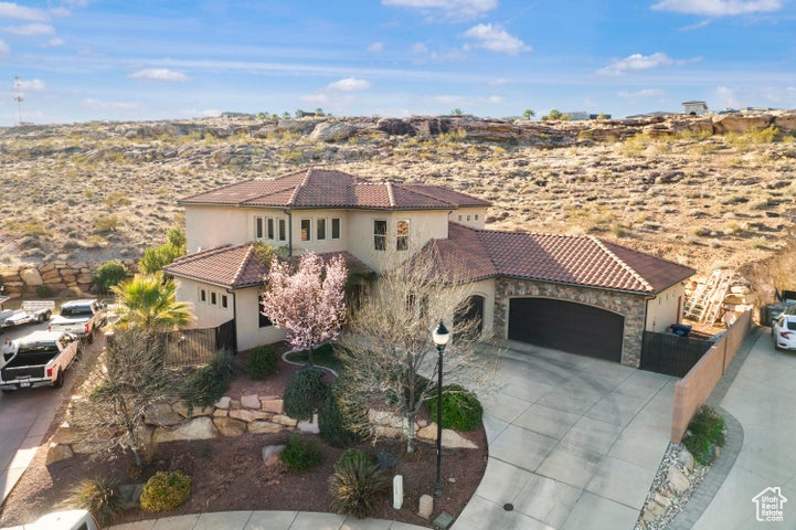 Mediterranean / spanish-style home with fence, an attached garage, driveway, and a tile roof