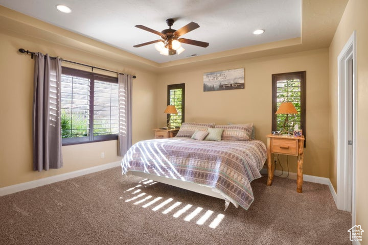 Bedroom featuring baseboards, carpet, and multiple windows
