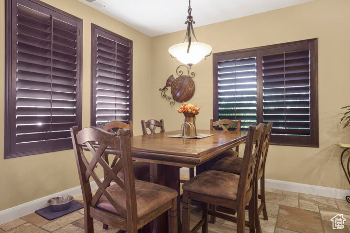Dining room featuring stone tile flooring and baseboards