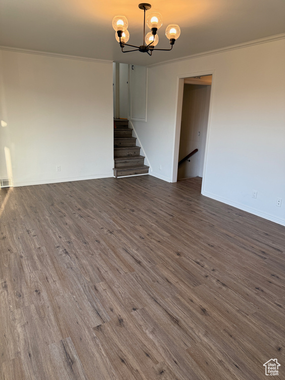 Interior space featuring an inviting chandelier, crown molding, and dark wood-type flooring
