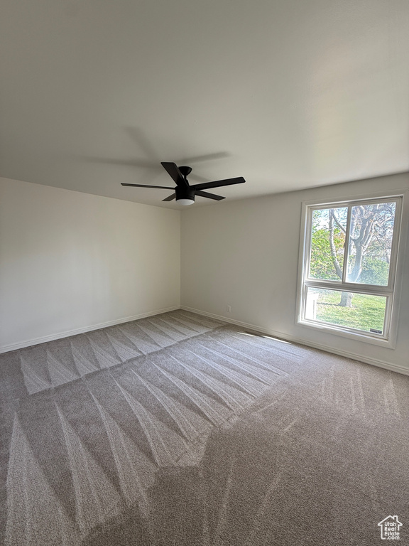 Spare room with baseboards, carpet flooring, and ceiling fan