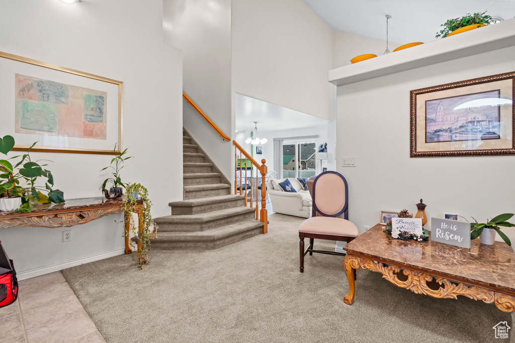 Interior space featuring stairs, high vaulted ceiling, an inviting chandelier, and baseboards