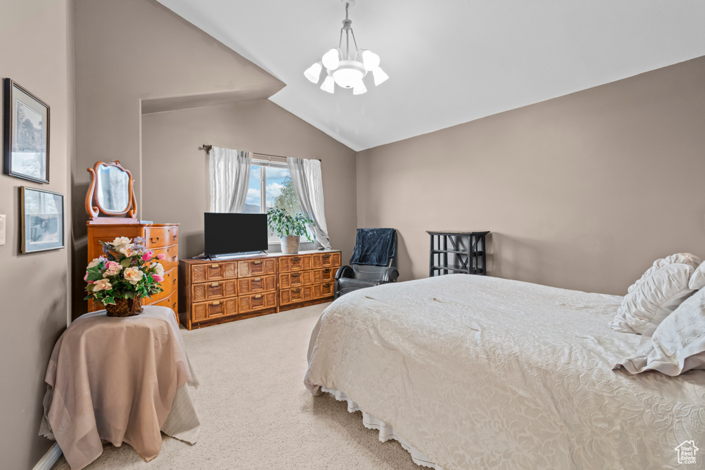 Carpeted bedroom featuring a chandelier and lofted ceiling