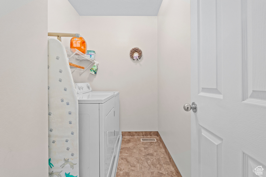 Laundry area featuring baseboards, visible vents, laundry area, and washing machine and clothes dryer