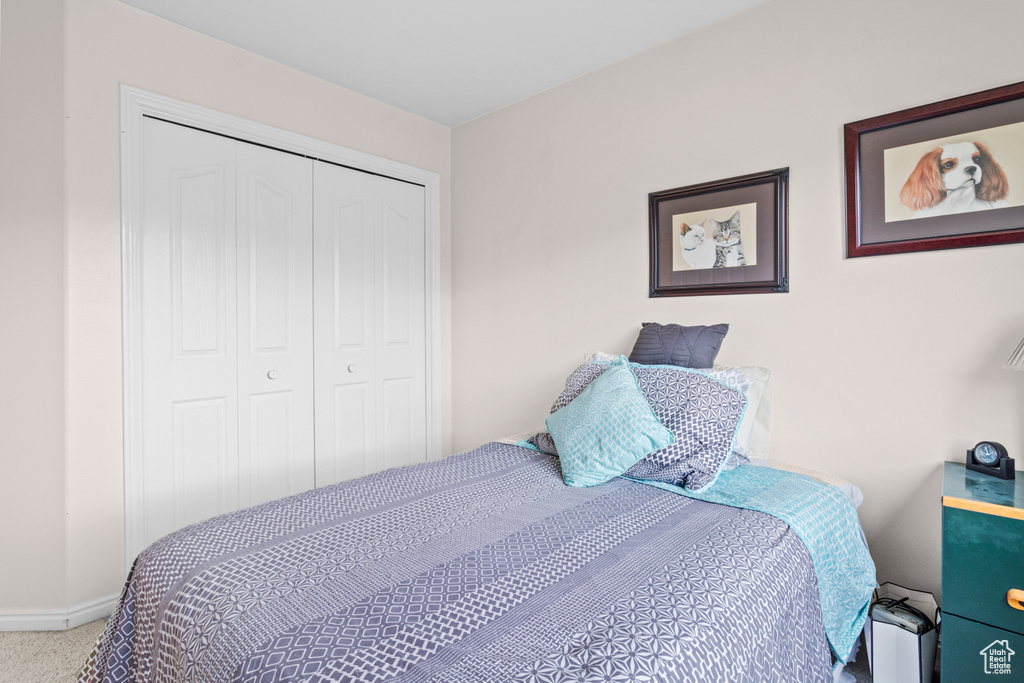 Carpeted bedroom with a closet and baseboards