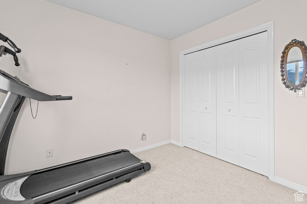 Workout room featuring baseboards and carpet flooring
