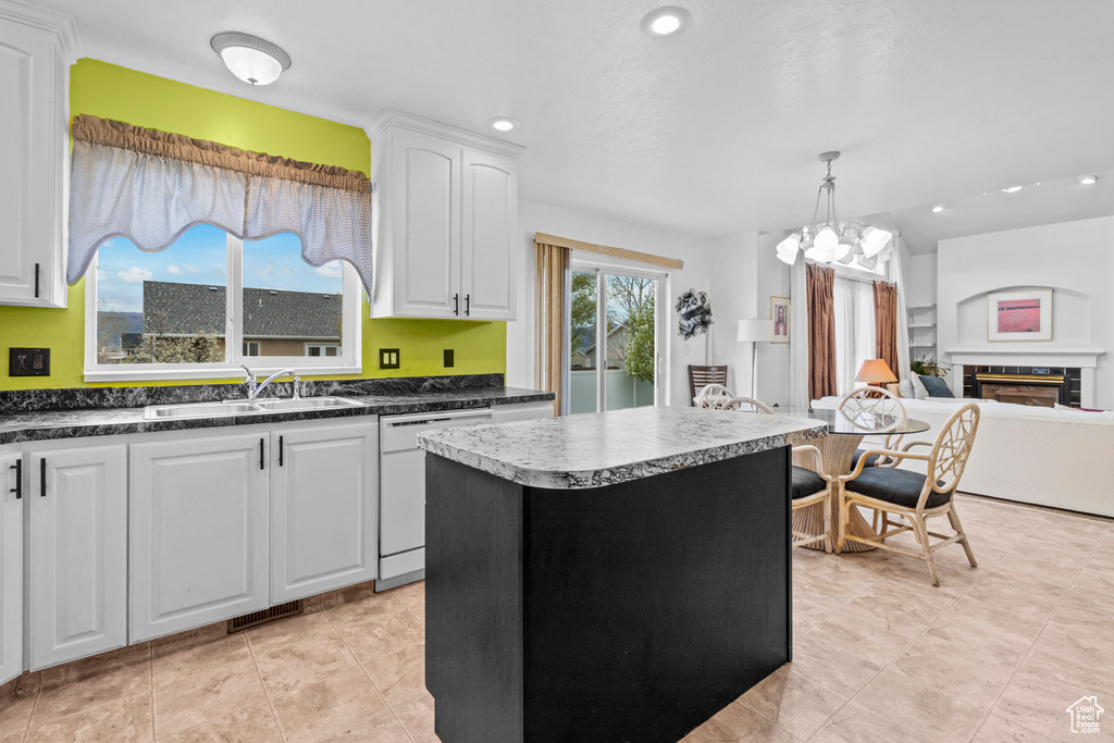 Kitchen featuring dark countertops, dishwasher, a sink, recessed lighting, and white cabinetry