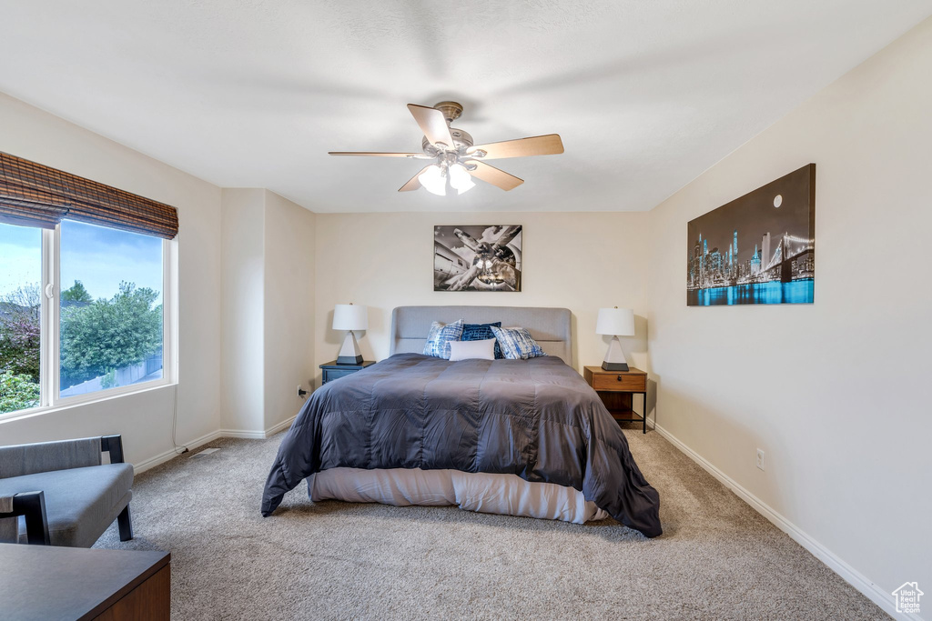 Bedroom with a ceiling fan, baseboards, and carpet