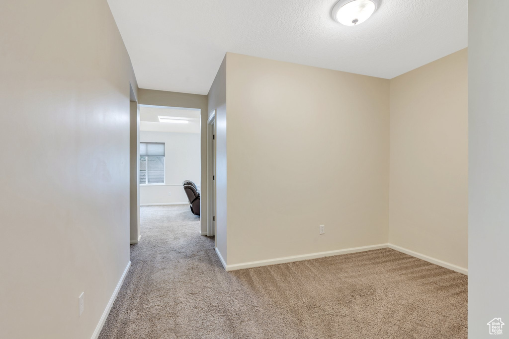 Corridor with carpet flooring and baseboards