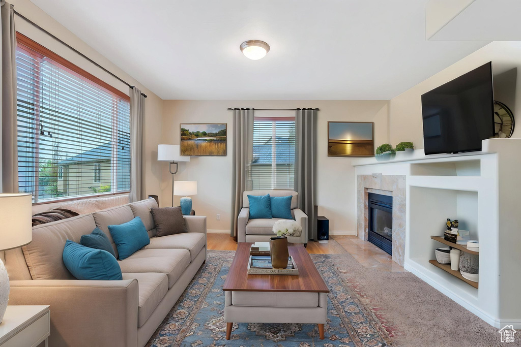 Living room featuring a tile fireplace, baseboards, and wood finished floors