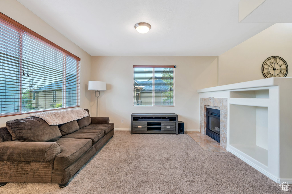 Carpeted living room featuring baseboards and a tile fireplace