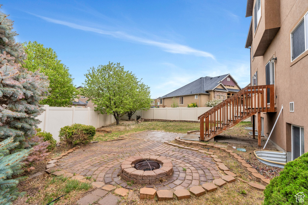 View of yard with a patio, a fenced backyard, stairs, and an outdoor fire pit