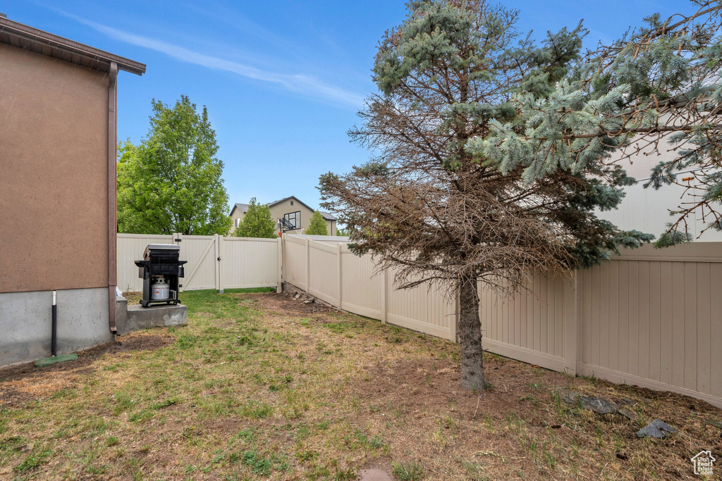 View of yard featuring a fenced backyard and a gate