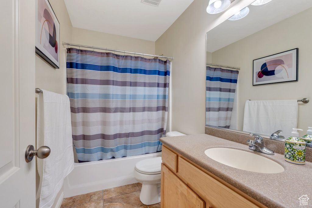 Bathroom with toilet, visible vents, shower / bath combo, and vanity