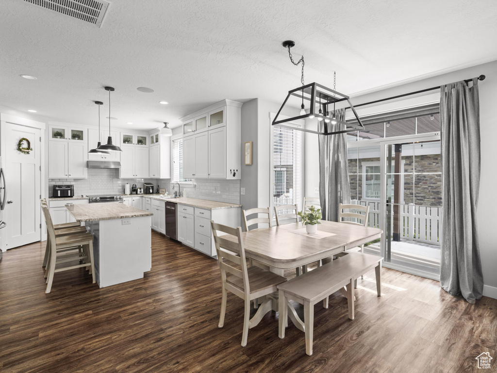 Dining space featuring visible vents, dark wood-style flooring, recessed lighting, a textured ceiling, and a notable chandelier