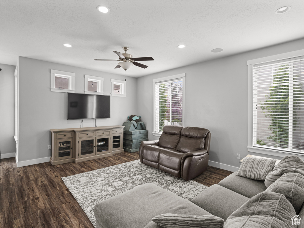 Living area with baseboards, recessed lighting, ceiling fan, and dark wood-type flooring