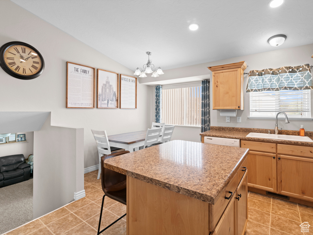 Kitchen featuring a kitchen island, light brown cabinetry, a sink, a chandelier, and recessed lighting