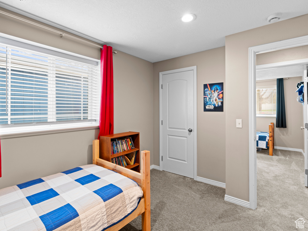 Bedroom featuring carpet floors and baseboards