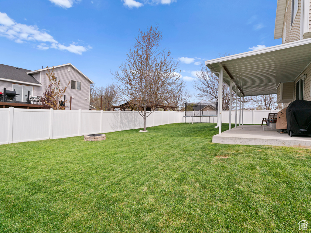 View of yard with a patio, a fenced backyard, and an outdoor fire pit