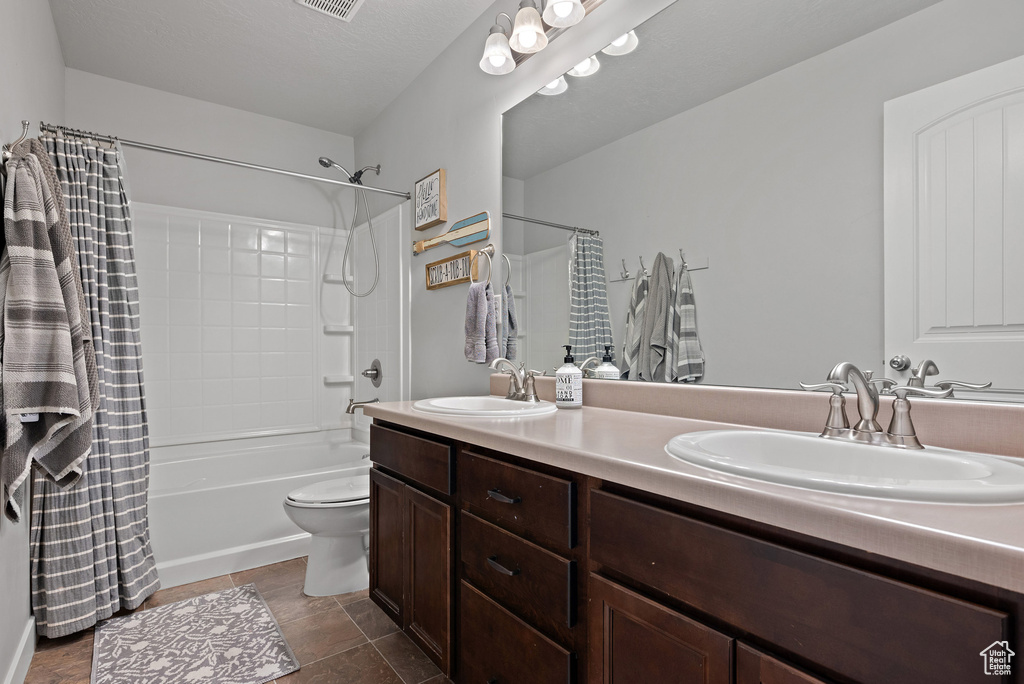 Full bath featuring double vanity, toilet, shower / bathtub combination with curtain, and a sink