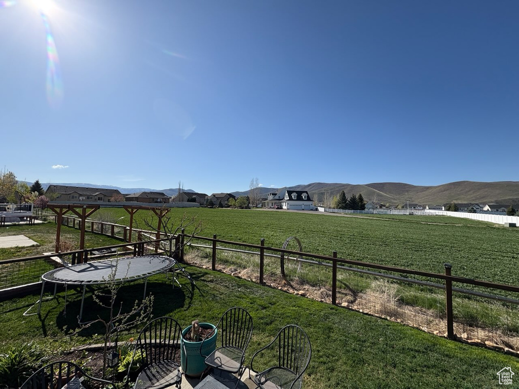 View of yard featuring fence, a mountain view, and a rural view