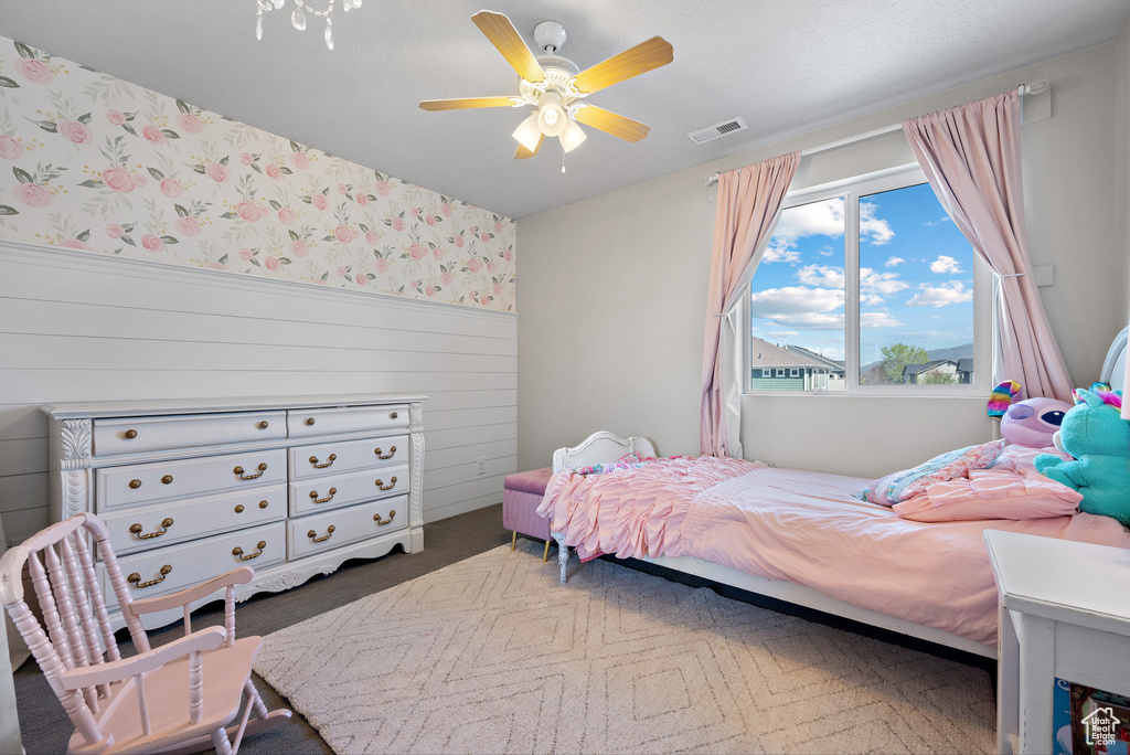 Bedroom featuring visible vents, a ceiling fan, a wainscoted wall, and wallpapered walls