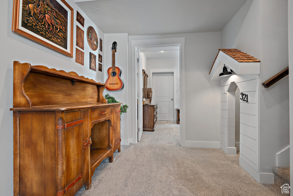 Hallway featuring carpet floors and baseboards