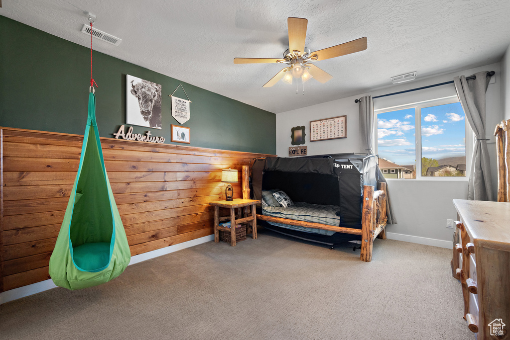 Bedroom with a textured ceiling, visible vents, baseboards, and carpet