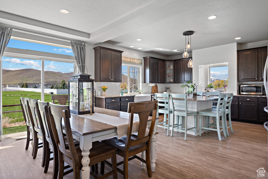 Dining area featuring recessed lighting, light wood-style flooring, a mountain view, and a textured ceiling