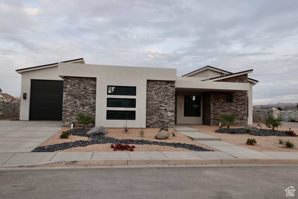 Modern home with stucco siding, concrete driveway, and stone siding