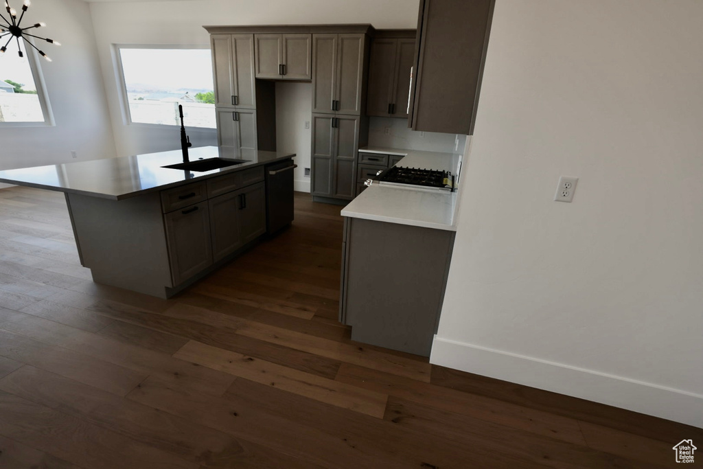 Kitchen with a center island, dark wood-style floors, a sink, and dishwasher