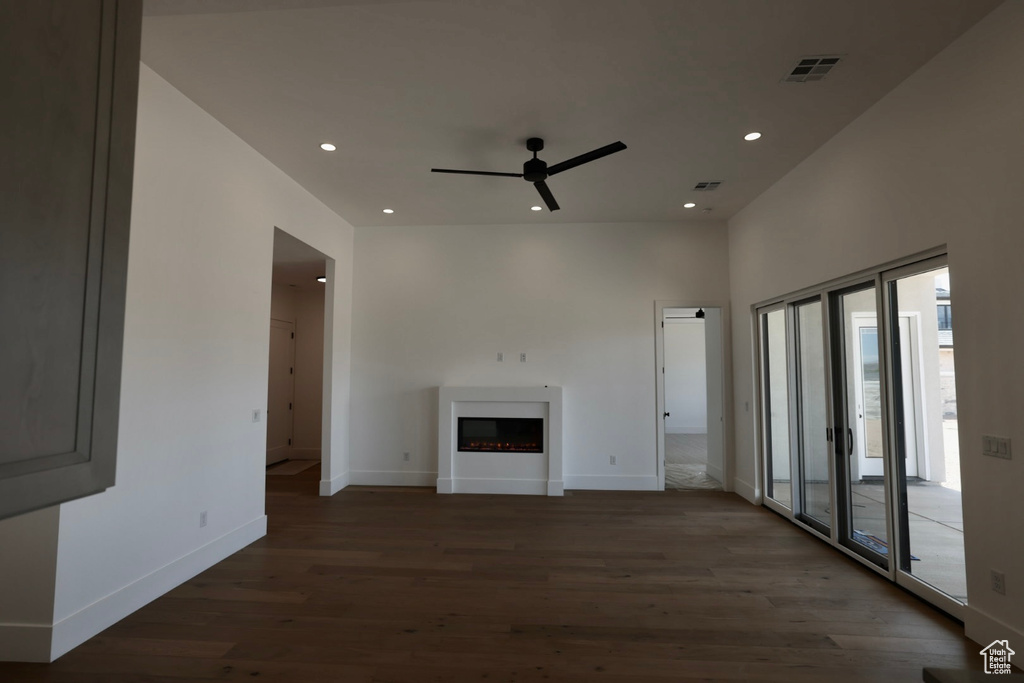 Unfurnished living room with wood finished floors, a fireplace, baseboards, ceiling fan, and recessed lighting
