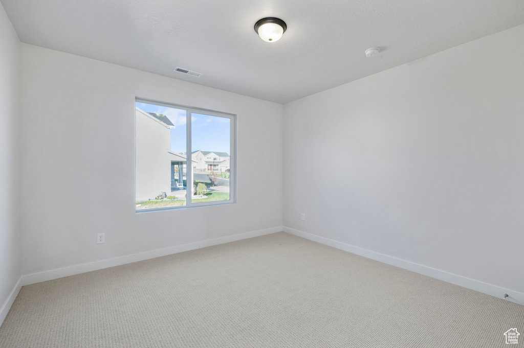 Carpeted spare room with baseboards and visible vents