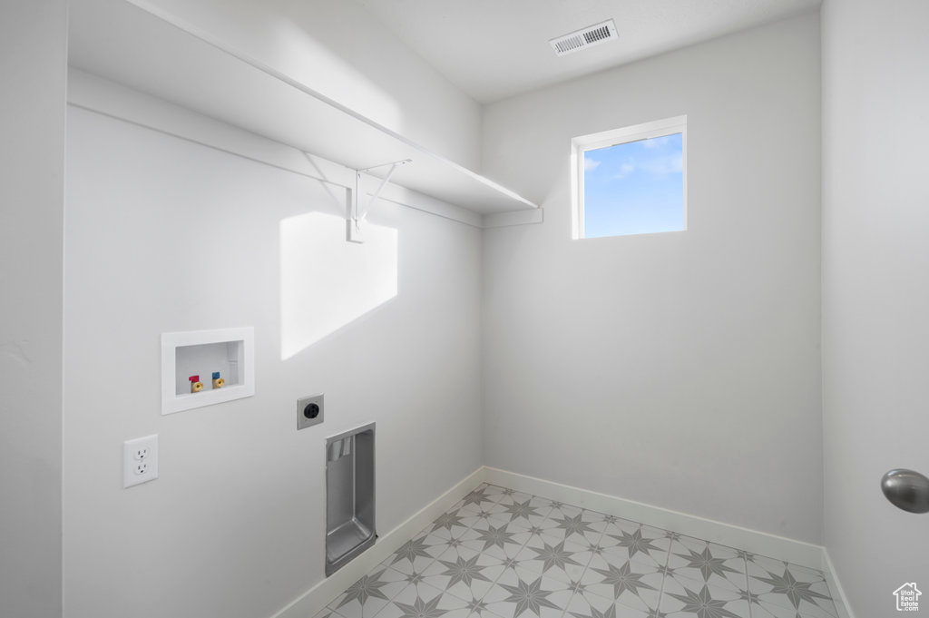 Washroom featuring laundry area, hookup for a washing machine, baseboards, light floors, and visible vents
