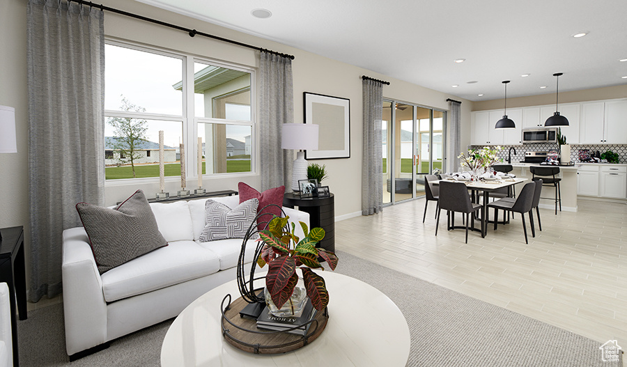 Living room featuring recessed lighting, baseboards, a wealth of natural light, and light wood-style floors