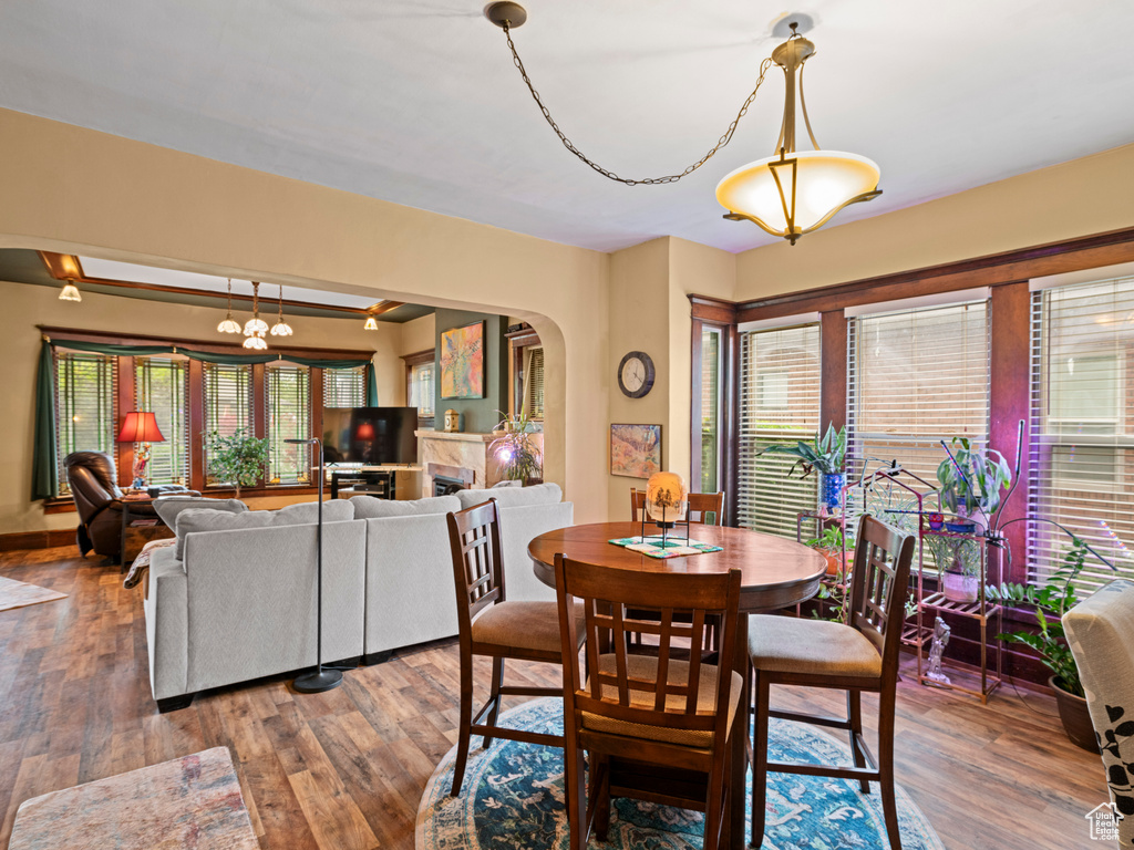 Dining area featuring plenty of natural light, arched walkways, and wood finished floors
