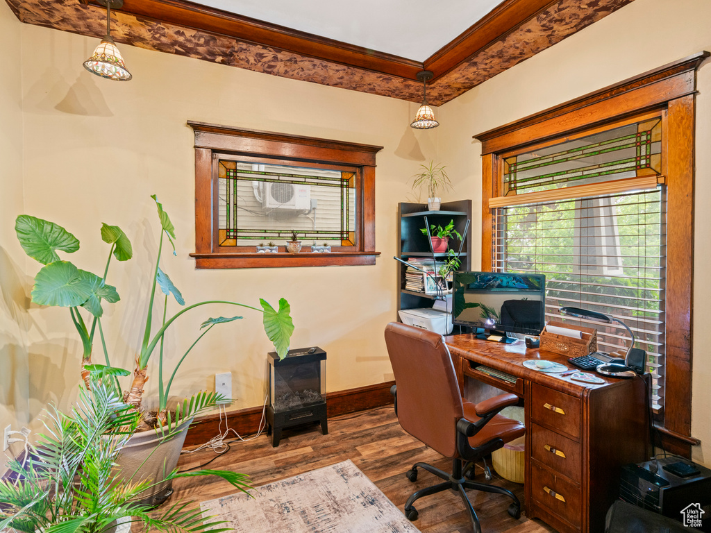 Home office featuring crown molding, baseboards, and wood finished floors