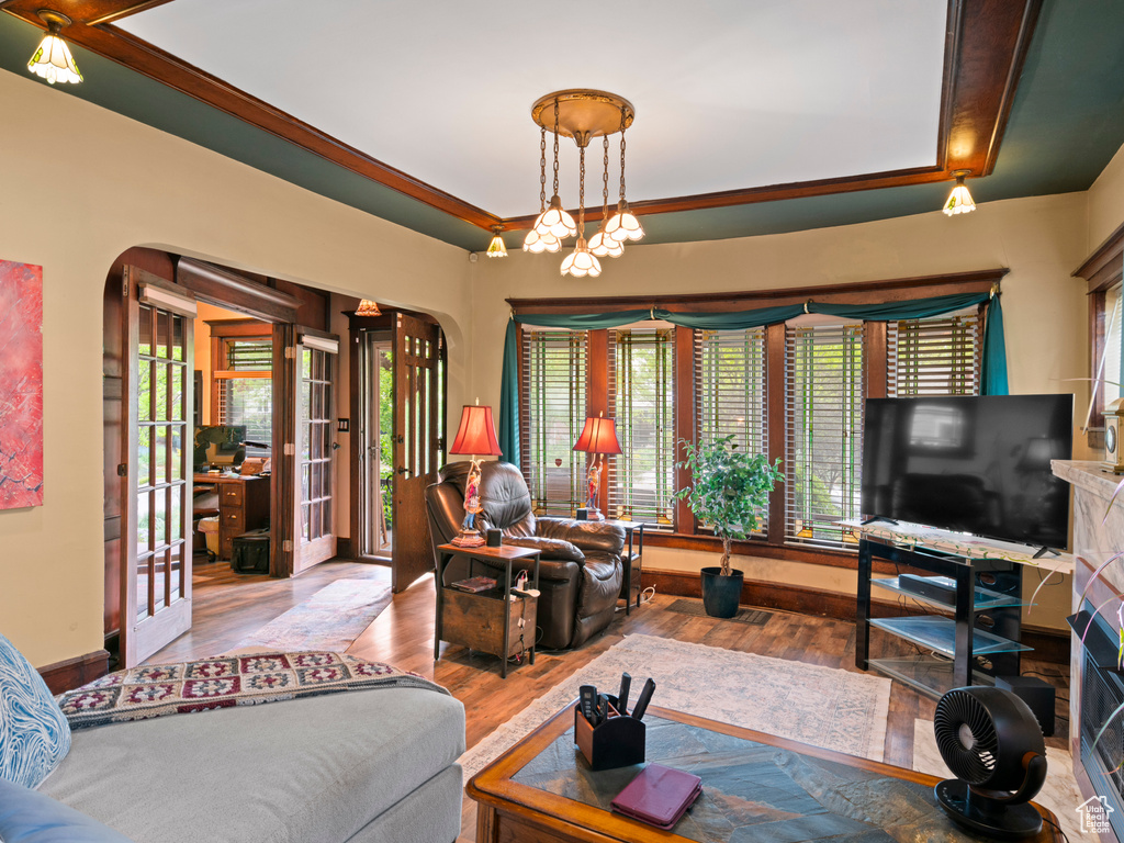 Living room featuring french doors, arched walkways, and wood finished floors