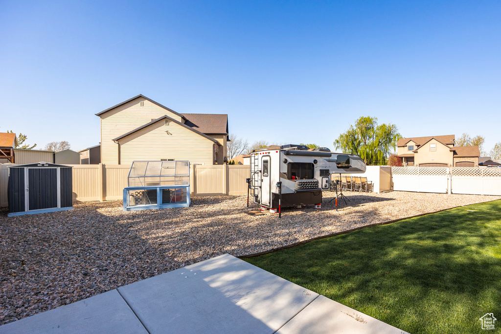 View of yard with a fenced backyard, a patio, and an outbuilding
