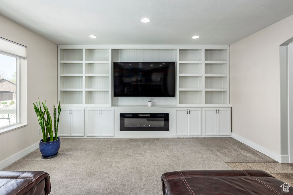 Unfurnished living room featuring recessed lighting, baseboards, built in features, and carpet
