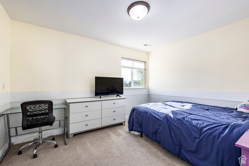 Bedroom with visible vents and light carpet