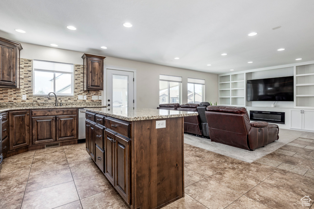 Kitchen with recessed lighting, a kitchen island, a healthy amount of sunlight, and dark brown cabinetry