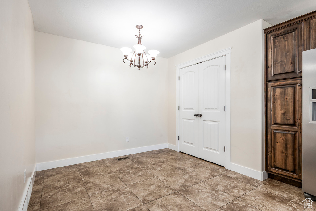 Interior space with baseboards, a notable chandelier, and visible vents