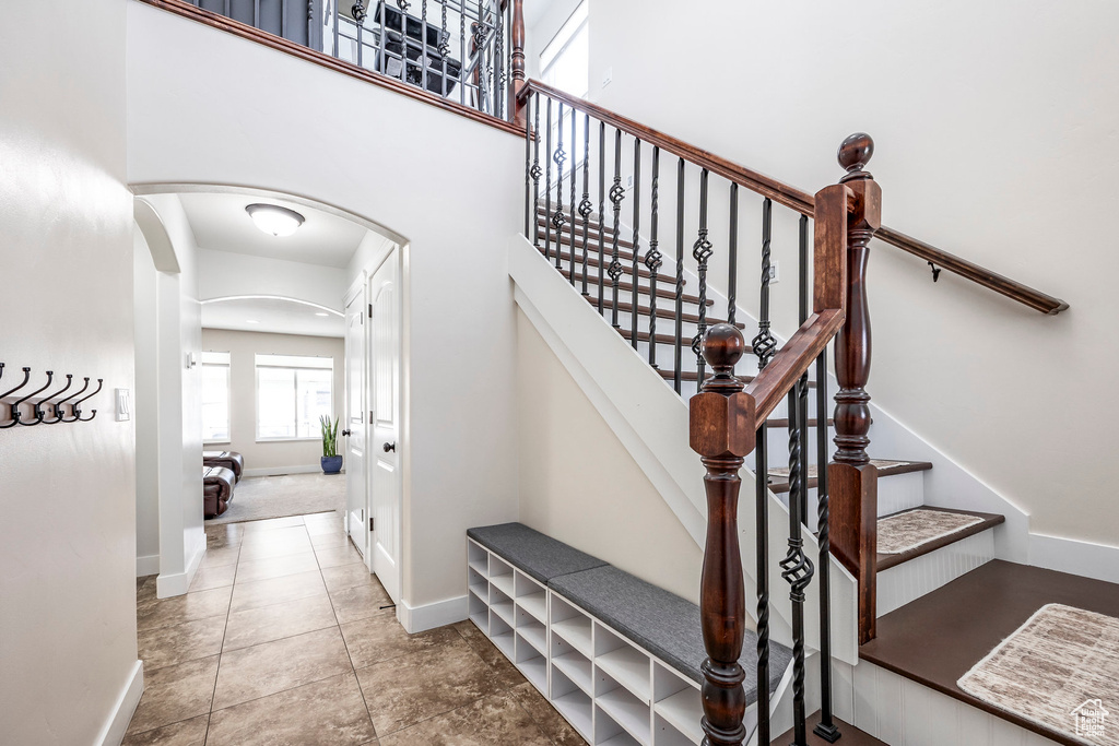 Staircase with arched walkways and baseboards